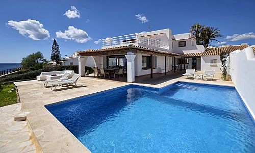 Poolterrasse mit Sonnenliegen vor dem Ferienhaus