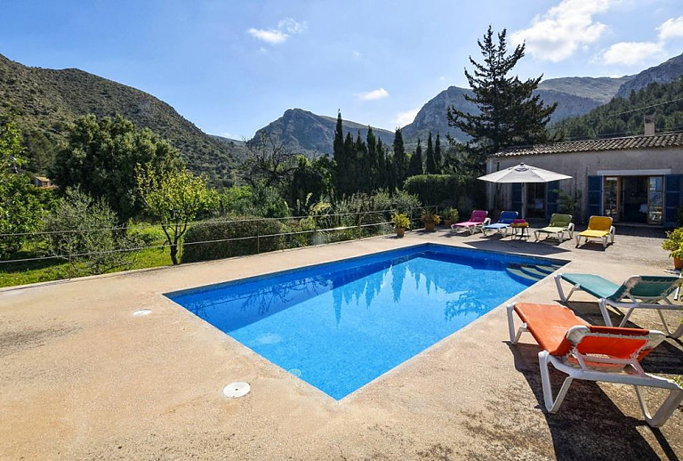 Poolterrasse mit Sonnenschirm und Poolliegen