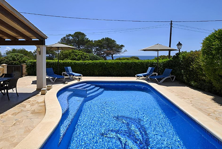 Sonnenschirm und Sonnenliegen am Pool