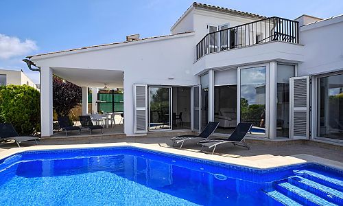 Poolterrasse mit Sonnenliegen vor dem Ferienhaus