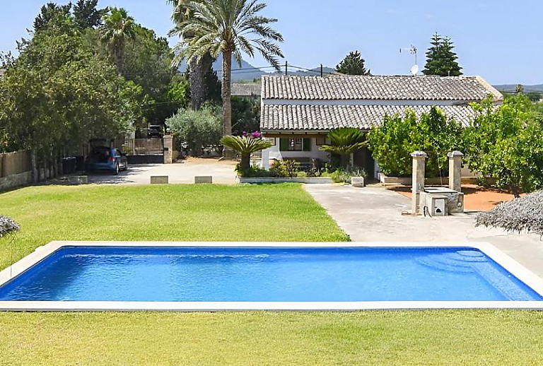Rasenfläche und Sonnenliegen am Pool