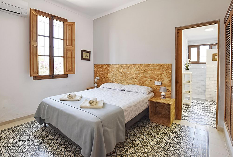 Schlafzimmer mit Doppelbett und Bad