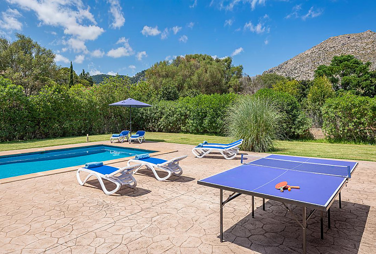 Tischtennisplatte und Sonnenliegen am Pool