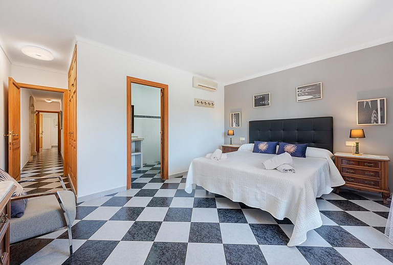 Schlafzimmer mit Doppelbett und Bad