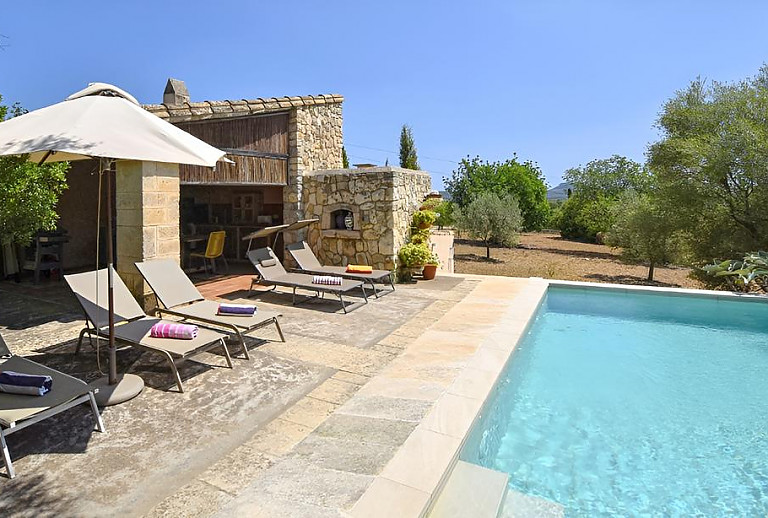 Sonnenliegen und Sonnenschirm vor der Finca