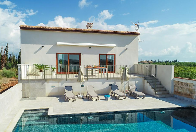 Poolterrasse und Sonnenliegen vor der Finca