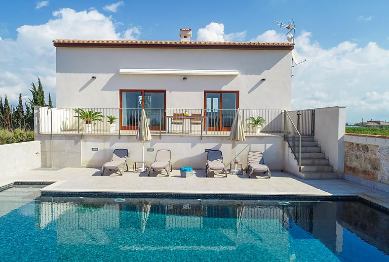 Sonnenliegen und Sonnenschirm am Poolbereich