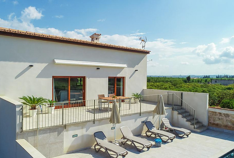 Terrasse mit Sonnenliegen und Esstisch