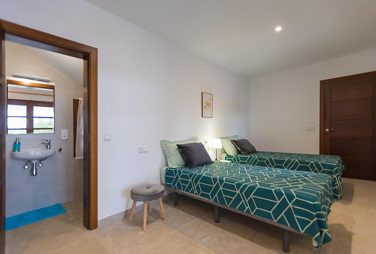 Schlafzimmer mit Einzelbetten und Bad