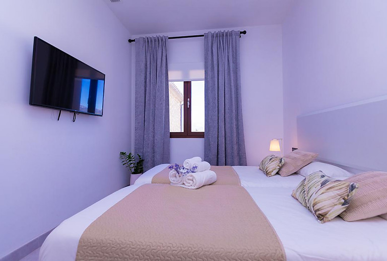 Schlafzimmer mit Einzelbetten und Fernseher