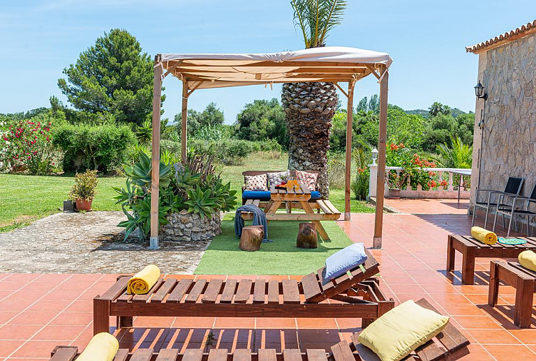 Garten mit Rasen und Terrasse mit Poolliegen