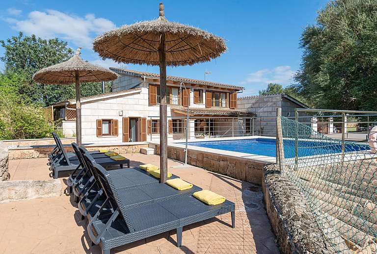 Sonnenliegen und Sonnenschirm am Poolbereich