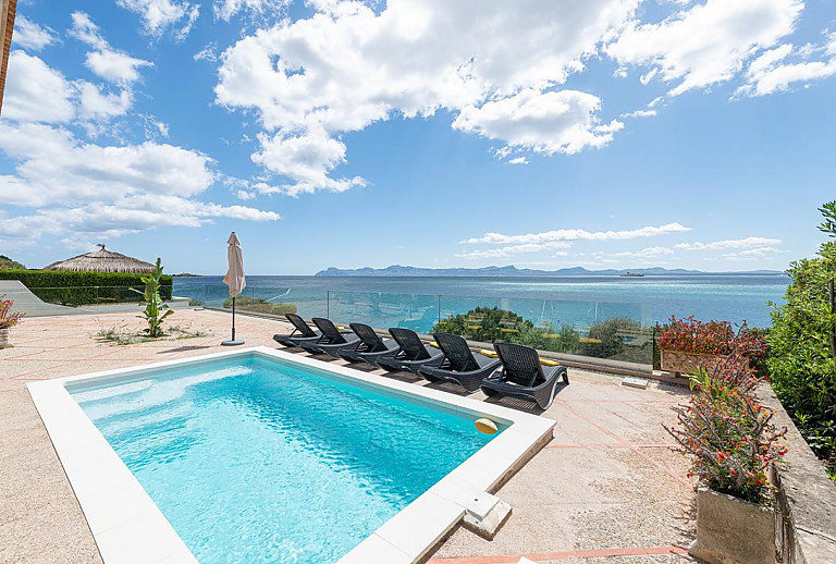 Sonnenliegen am Pool mit Meerblick