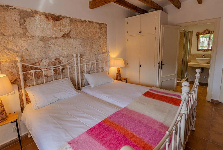 Schlafzimmer mit Einzelbetten und Natursteinwand