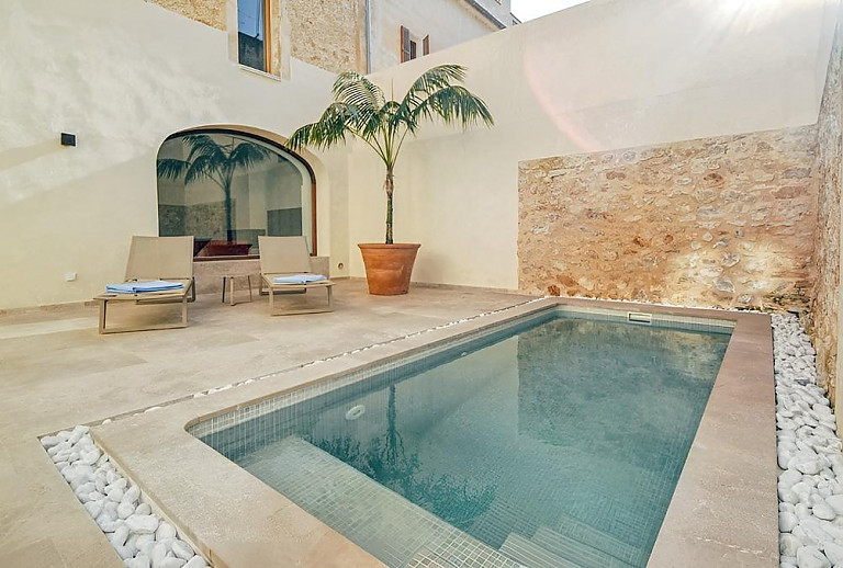 Pool und Sonnenliegen im Innenhof