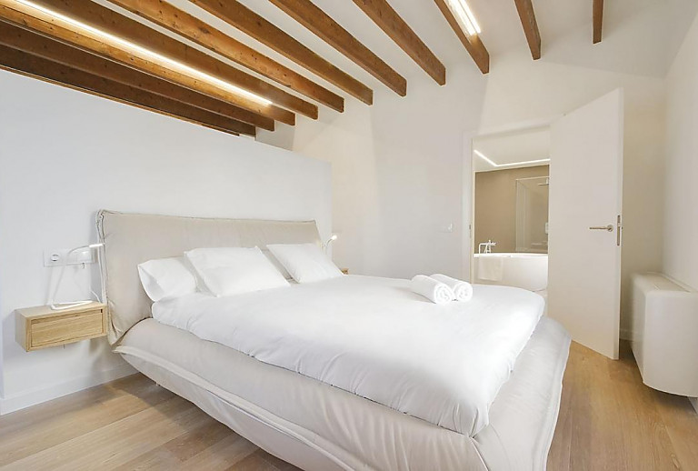 Schlafzimmer mit Doppelbett und Bad