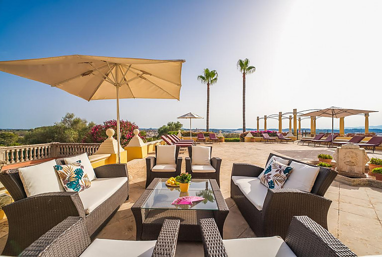 Terrasse mit Sitzmöbeln und Sonnenliegen