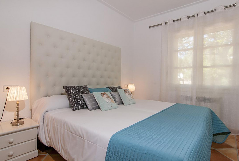 Schlafzimmer mit Doppelbett und Nachttisch