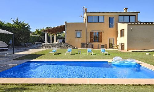 Poolbereich mit Rasenfläche und Sonnenliegen