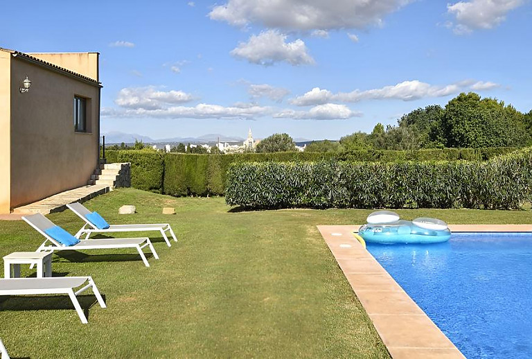 Sonnenliegen und Hecken am Poolbereich