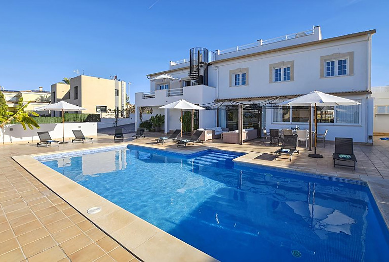 Pool mit Sonnenschirmen und Poolliegen