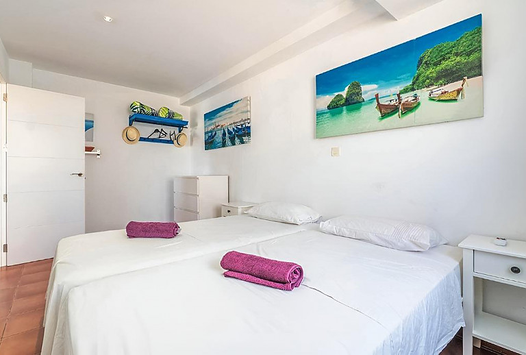 Schlafzimmer mit Einzelbetten und Wandbildern