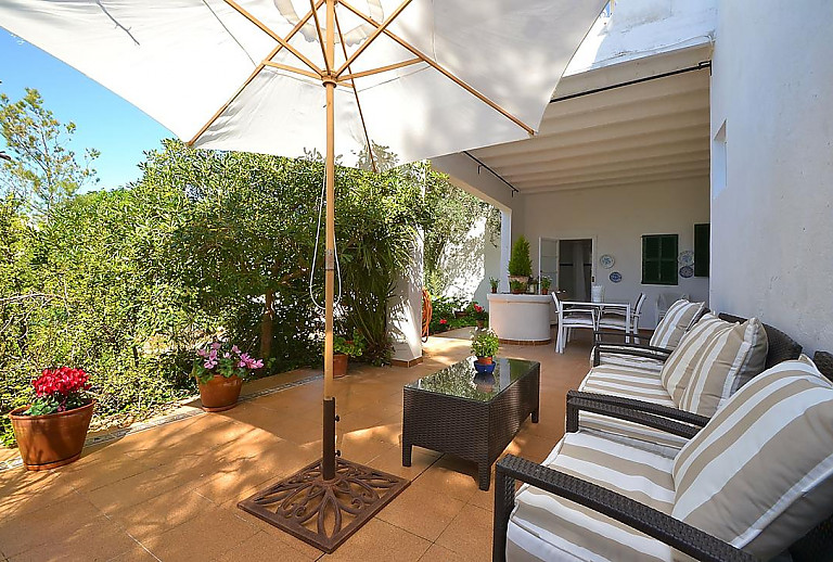 Terrasse mit Topfpflanzen und Gartenmöbeln