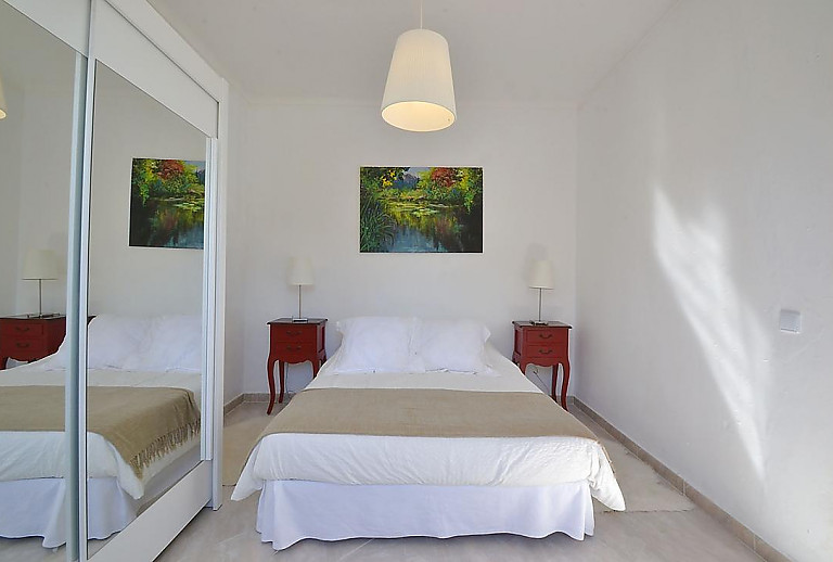 Schlafzimmer mit Doppelbett und Nachttisch