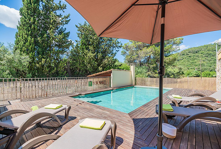Sonnenliegen und Sonnenschirm am Poolbereich