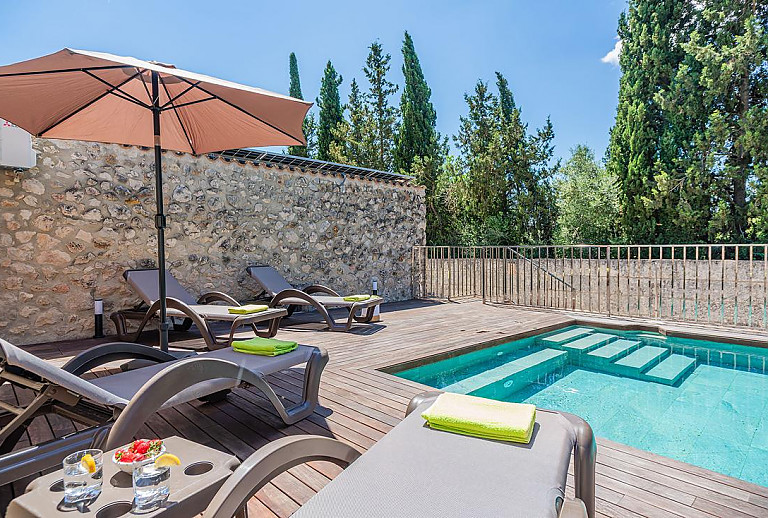 Poolbereich mit Sonnenschirm und Poolliegen