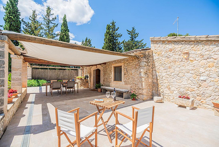Terrasse mit Vordach und Gartenmöbeln