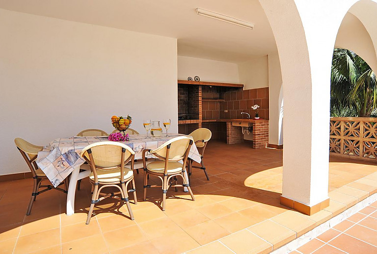 Terrasse mit Esstisch und Sommerküche