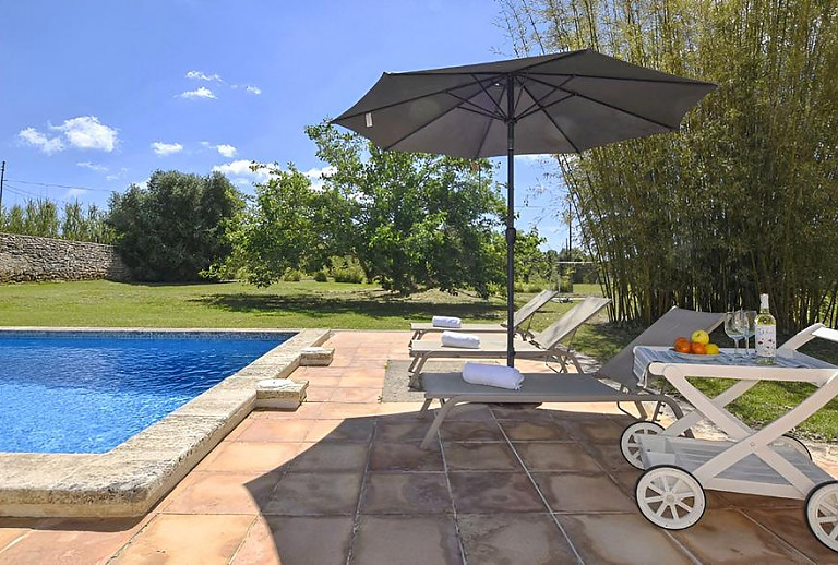 Sonnenliegen und Sonnenschirm am Poolbereich