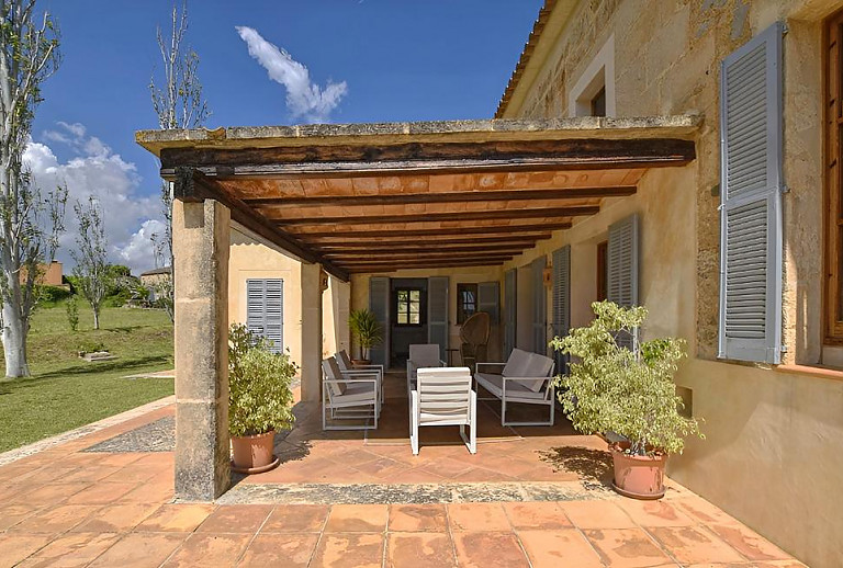 Terrasse mit Vordach und Gartenmöbeln