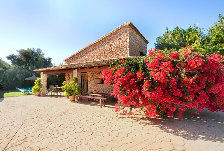 Finca Natursteinfassade Blumen Büsche