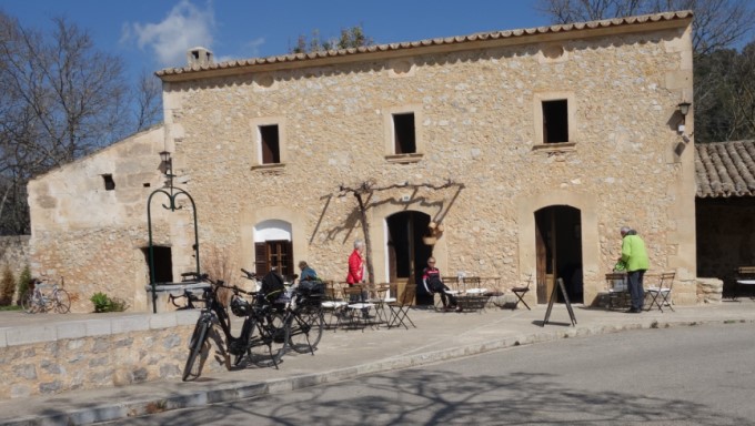 Haus mit Fährrädern und altem Brunnen